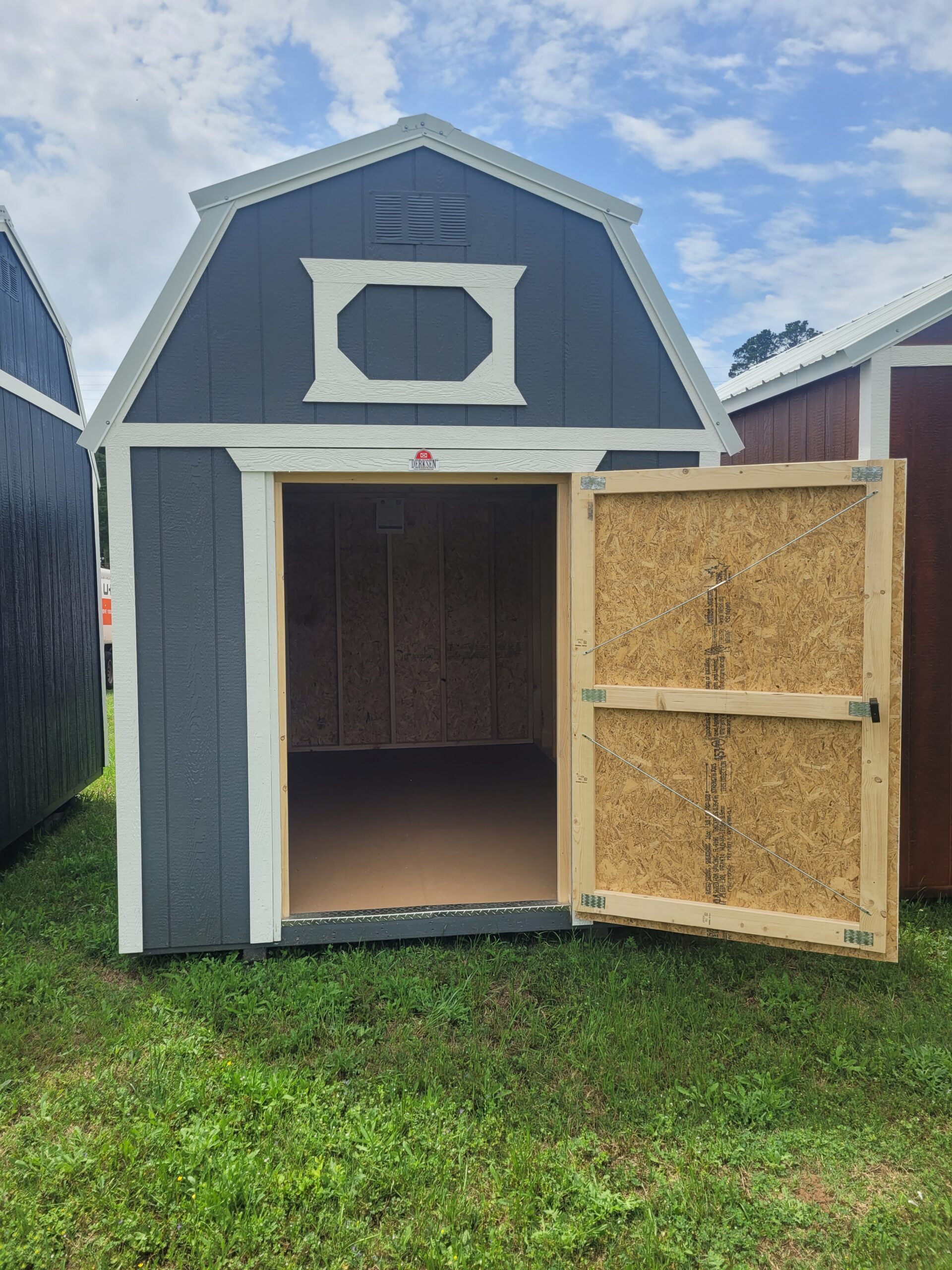 Portable barn placed beside backyard fence for mower, tools, and seasonal storage, Experienced Shed Builder measuring roof framing on a partially completed backyard storage shed