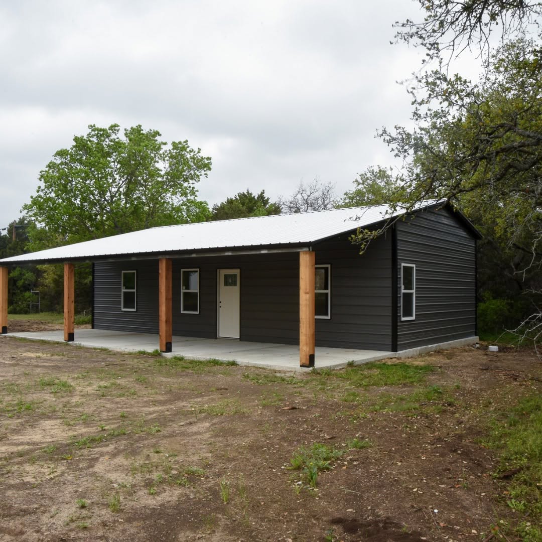 Large steel building sheltering equipment and work area on a Montgomery County property, Skilled Shed Builder checking roof alignment on a newly framed outdoor storage building