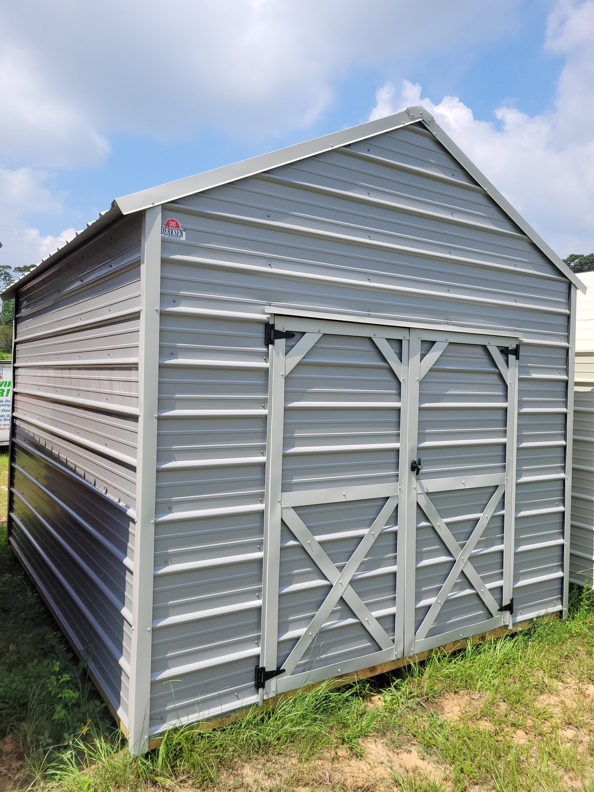 Utility building beside driveway storing tools, bins, and lawn equipment for daily access